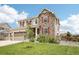 Attractive home with stone facade, red shutters, green lawn, and tidy landscaping at 16881 E 110Th Ave, Commerce City, CO 80022