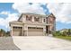 Stunning home with a three-car garage, stone detailing, and a well-manicured front yard at 16881 E 110Th Ave, Commerce City, CO 80022