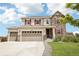 Lovely two-story home features a three-car garage, stone accents, and a charming front porch at 16881 E 110Th Ave, Commerce City, CO 80022