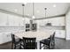 Bright kitchen boasts white cabinets, stainless steel appliances, and a large island with chairs at 16881 E 110Th Ave, Commerce City, CO 80022