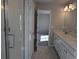 Bright bathroom featuring double sinks, quartz countertops, and a glass enclosed tiled shower at 16815 Mckay Dr, Mead, CO 80542