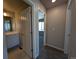 Hallway featuring tile flooring, multiple doors, a view into a carpeted bedroom, and bathroom vanity at 16815 Mckay Dr, Mead, CO 80542
