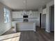 Modern kitchen with white cabinets, stainless steel appliances, an island, and hardwood floors at 16815 Mckay Dr, Mead, CO 80542