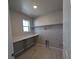 Well-lit laundry room with tile flooring, a window, quartz countertops, and ample shelf space at 16815 Mckay Dr, Mead, CO 80542