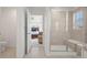 Bathroom features glass enclosed shower with tile surround and a door that leads to primary bedroom at 8372 Bijou Creek Ave, Littleton, CO 80125