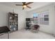 Bright bedroom with a ceiling fan, large bookcase filled with books, and a modern desk with two monitors at 8372 Bijou Creek Ave, Littleton, CO 80125