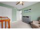 Relaxing bedroom features soft green walls and a wooden crib adding charm to the space at 8372 Bijou Creek Ave, Littleton, CO 80125
