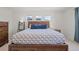 Bright bedroom featuring three windows above a wooden bed frame for ample natural light at 8372 Bijou Creek Ave, Littleton, CO 80125