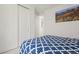 A bedroom with a blue patterned comforter, a closet with white sliding doors, and a window at 8372 Bijou Creek Ave, Littleton, CO 80125