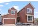 Charming two-story home featuring a garage and covered entryway on a sunny day at 8372 Bijou Creek Ave, Littleton, CO 80125