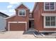 Charming two-story home featuring a garage and covered entryway on a sunny day at 8372 Bijou Creek Ave, Littleton, CO 80125