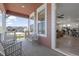 Inviting covered front porch with gray wood deck, bench seating, and view to inside the home at 8372 Bijou Creek Ave, Littleton, CO 80125