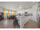 Modern, open kitchen with white cabinetry, stainless steel appliances, and a granite island with seating at 8372 Bijou Creek Ave, Littleton, CO 80125