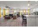 Bright, open living space with hardwood floors, yellow accents, and a view of the kitchen island at 8372 Bijou Creek Ave, Littleton, CO 80125