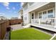 Landscaped backyard features artificial grass, rock landscaping, and a covered porch at 9503 Richfield St, Commerce City, CO 80022