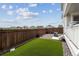 Fenced backyard featuring artificial grass, rock landscaping, and privacy at 9503 Richfield St, Commerce City, CO 80022