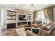 Cozy living room features a stone fireplace, floating shelves, and modern lighting at 9503 Richfield St, Commerce City, CO 80022