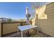 Enclosed balcony with a white table under a closed umbrella, offering a view of the surrounding landscape at 8915 Federal Blvd # 203, Denver, CO 80260
