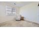 Cozy bedroom with a comfortable chair, side table, large window with blinds, and soft carpet at 8915 Federal Blvd # 203, Denver, CO 80260
