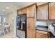 Modern kitchen with dark countertops, stainless appliances, and wooden cabinets flowing into dining area at 8915 Federal Blvd # 203, Denver, CO 80260