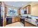 Functional kitchen featuring wooden cabinets, black appliances, and sleek countertops at 8915 Federal Blvd # 203, Westminster, CO 80260