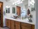 Bright bathroom featuring a double vanity with white countertops and oak cabinetry at 5695 W 109Th Cir, Westminster, CO 80020