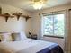 Cozy bedroom showcasing a ceiling fan and a large window, complemented by decor on wall shelves at 5695 W 109Th Cir, Westminster, CO 80020