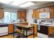 Functional kitchen featuring oak cabinets, white countertops, and appliances, island with storage at 5695 W 109Th Cir, Westminster, CO 80020