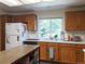 Functional kitchen featuring oak cabinets, white appliances, island with storage, and a large window at 5695 W 109Th Cir, Westminster, CO 80020