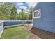 Serene backyard includes an artificial lawn and wooded area, beautifully enclosed by a blue fence at 5016 S Nelson St # C, Littleton, CO 80127