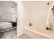 Bright bathroom with soaking tub, neutral walls and carpet with view into the bedroom at 5016 S Nelson St # C, Littleton, CO 80127