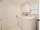 Bright laundry room boasts modern washer and dryer set with convenient overhead cabinet storage at 5016 S Nelson St # C, Littleton, CO 80127