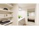 Bathroom with double vanity, linen shelves, and bedroom view at 22313 E 38Th Pl, Aurora, CO 80019