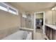 Bathroom featuring a bathtub, separate glass shower, double sinks, and a walk in closet at 10452 Rutledge St, Parker, CO 80134