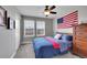 Bedroom featuring a bed, dresser, an American flag, and dual windows for natural light at 10452 Rutledge St, Parker, CO 80134