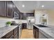 Well-appointed kitchen with dark cabinets, stainless steel appliances, and a center island with breakfast bar at 10452 Rutledge St, Parker, CO 80134