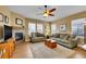 Cozy living room with a fireplace, comfortable seating, and a ceiling fan for added comfort at 10452 Rutledge St, Parker, CO 80134