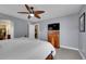 Stylish main bedroom with a ceiling fan, gray walls, and a wooden dresser for storage at 10452 Rutledge St, Parker, CO 80134