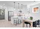 Bright kitchen with island, stainless appliances, modern lighting and white cabinetry at 4640 W 39Th Ave, Denver, CO 80212