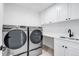Well-equipped laundry room with modern washer and dryer units, cabinets, and counter space at 4640 W 39Th Ave, Denver, CO 80212