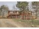 Rustic home with fenced yard, deck, and wooded surroundings provides a serene outdoor living experience at 26167 De Berry St, Conifer, CO 80433
