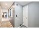 Hallway with white door leading to an open-concept kitchen and living area at 26167 De Berry St, Conifer, CO 80433