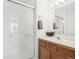 Bathroom featuring a glass shower, single sink, mirror, and brown wooden cabinets at 711 Elm St, Frederick, CO 80530