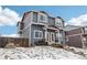 Stylish two-story townhome with a blue exterior, white trim, and a red roof, set against a cloudy sky in winter at 711 Elm St, Frederick, CO 80530