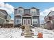 Attractive two-story townhouse featuring a blue exterior with red roof accents in a winter setting at 711 Elm St, Frederick, CO 80530