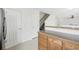 View of the kitchen and staircase with white walls, wooden cabinets and gray countertops at 711 Elm St, Frederick, CO 80530