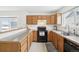 Bright kitchen featuring wooden cabinets, modern appliances, a gray countertop, and a window at 711 Elm St, Frederick, CO 80530