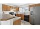 Well-lit kitchen features wooden cabinets, modern appliances, and a sink with a window overlooking the neighborhood at 711 Elm St, Frederick, CO 80530