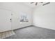 Bright living room featuring a large window, white door, and neutral carpet, creating an inviting and airy space at 711 Elm St, Frederick, CO 80530