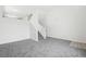 Minimalist living room featuring neutral carpet, white walls, and stairs to the upper level, offering a clean aesthetic at 711 Elm St, Frederick, CO 80530